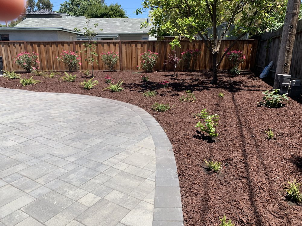 Paver patio installed by Opulands with garden area
